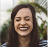 A woman grinning widely with her eyes closed